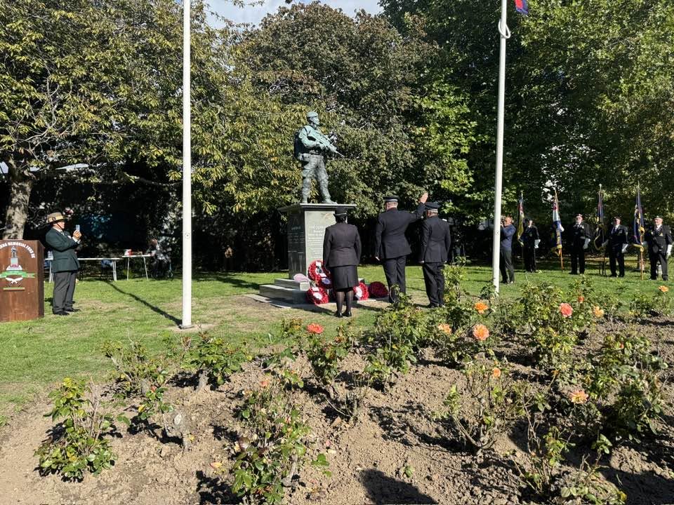 Dignitaries, uniformed officers and community members saluting during the Gurkha Memorial Day ceremony